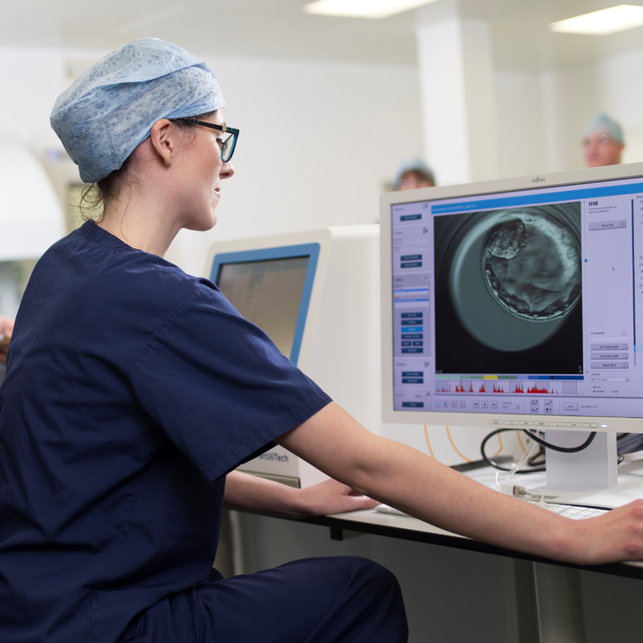 Specialist embryologists using an EmbryoScope and iDAScore software to analyse and embryo