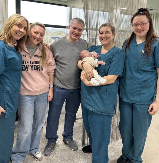 Baby Georgia and parents with Manchester Fertility team