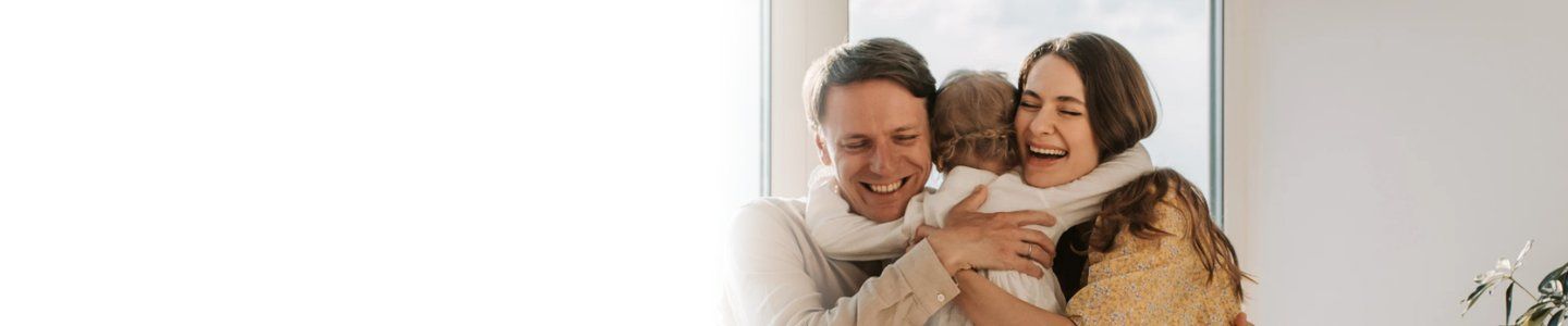 family simniling and cuddling - modified natural cycle ivf from manchester fertility