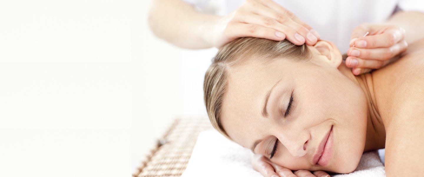 A woman lying down having acupuncture therapy