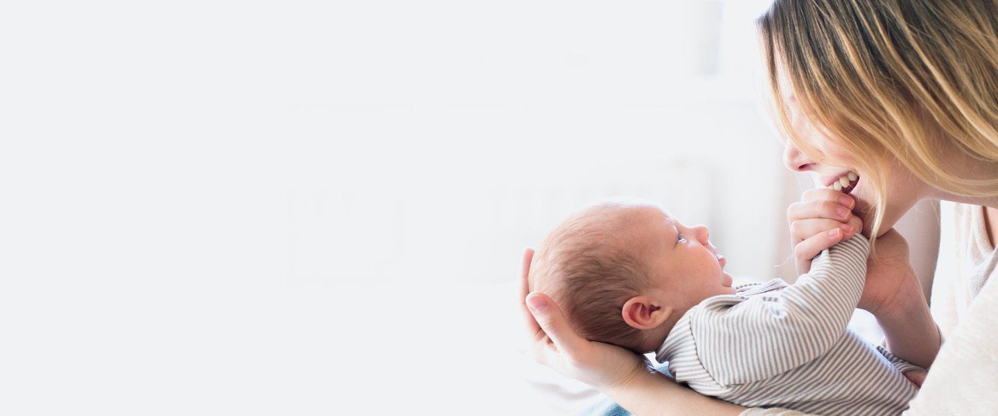 Mother holding baby in her arms smiling