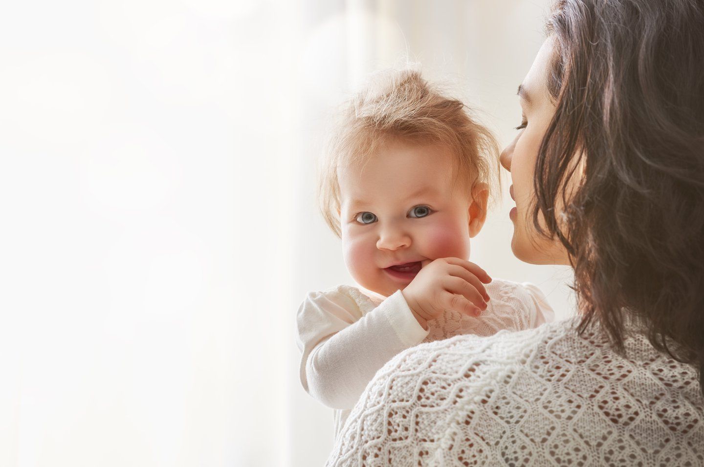 Baby looking at the camera with finger in his mouth