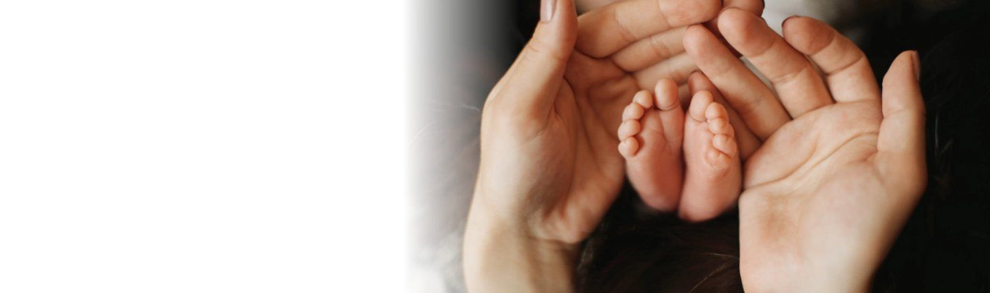 parents holding their new baby's feet after using ivf with donor eggs