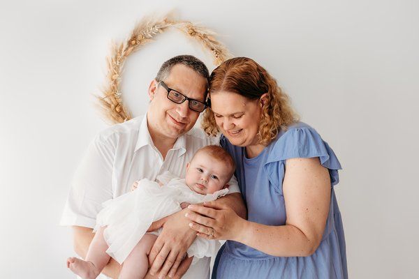 Mum Charlotte, Dad Ashley & Baby Emily cuddling together for a photo