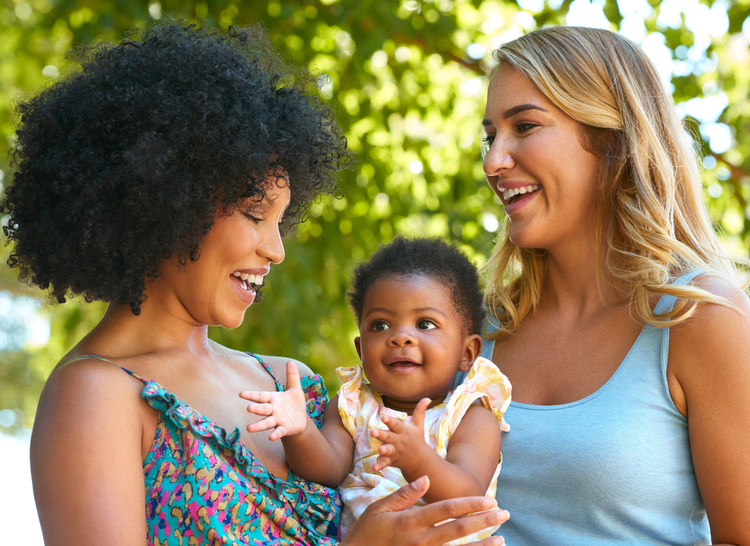 lesbian couple outside in nature with their baby