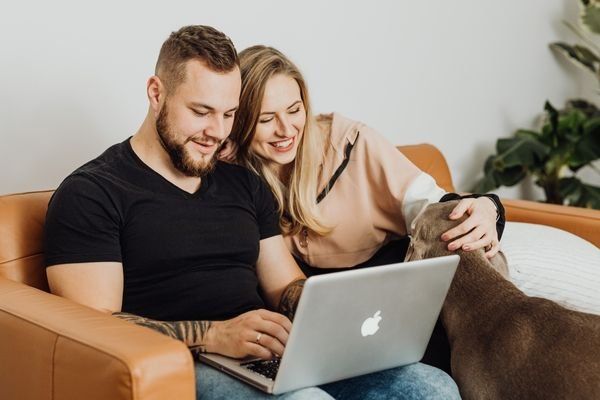 Couple with dog, sitting on the sofa accessing the support group