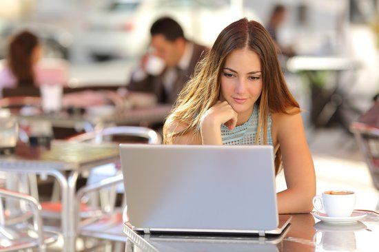 girl on her laptop with a coffee researching ivf