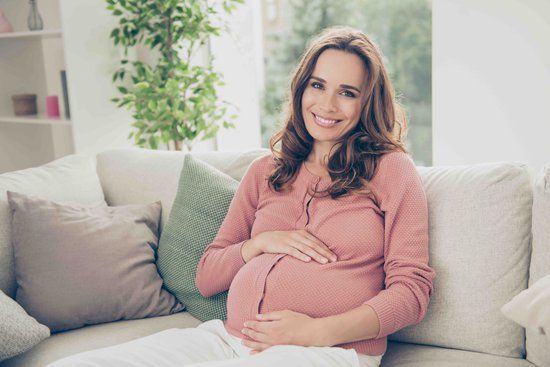 Older mum over 40s pregnant holding her bump