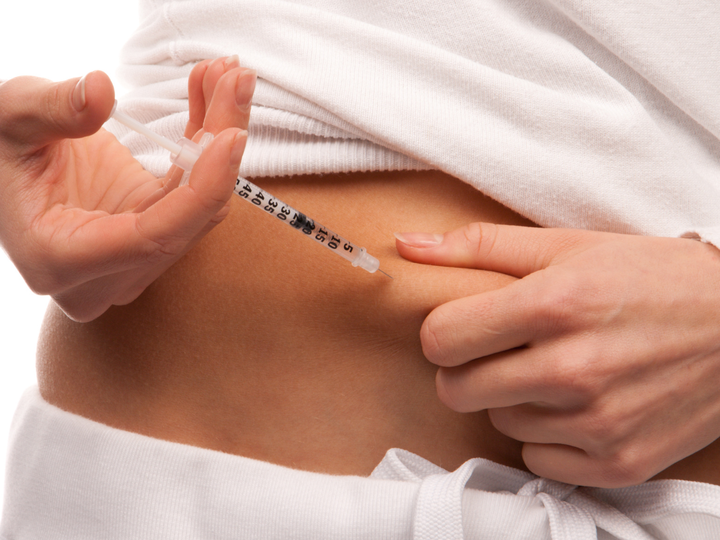 Women taking a hormone injection as part of her IVF treatment