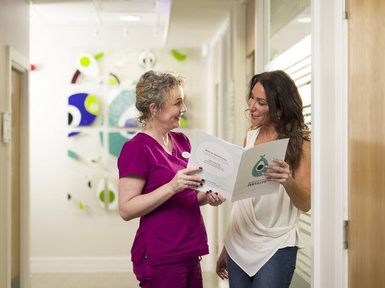 Two women at the clinic discussing frozen embryo transfer